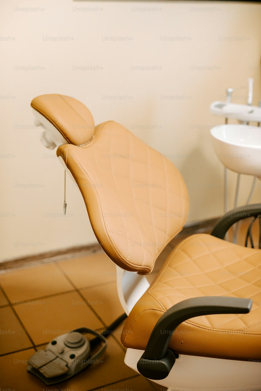 a tan leather chair sitting in a bathroom next to a sink