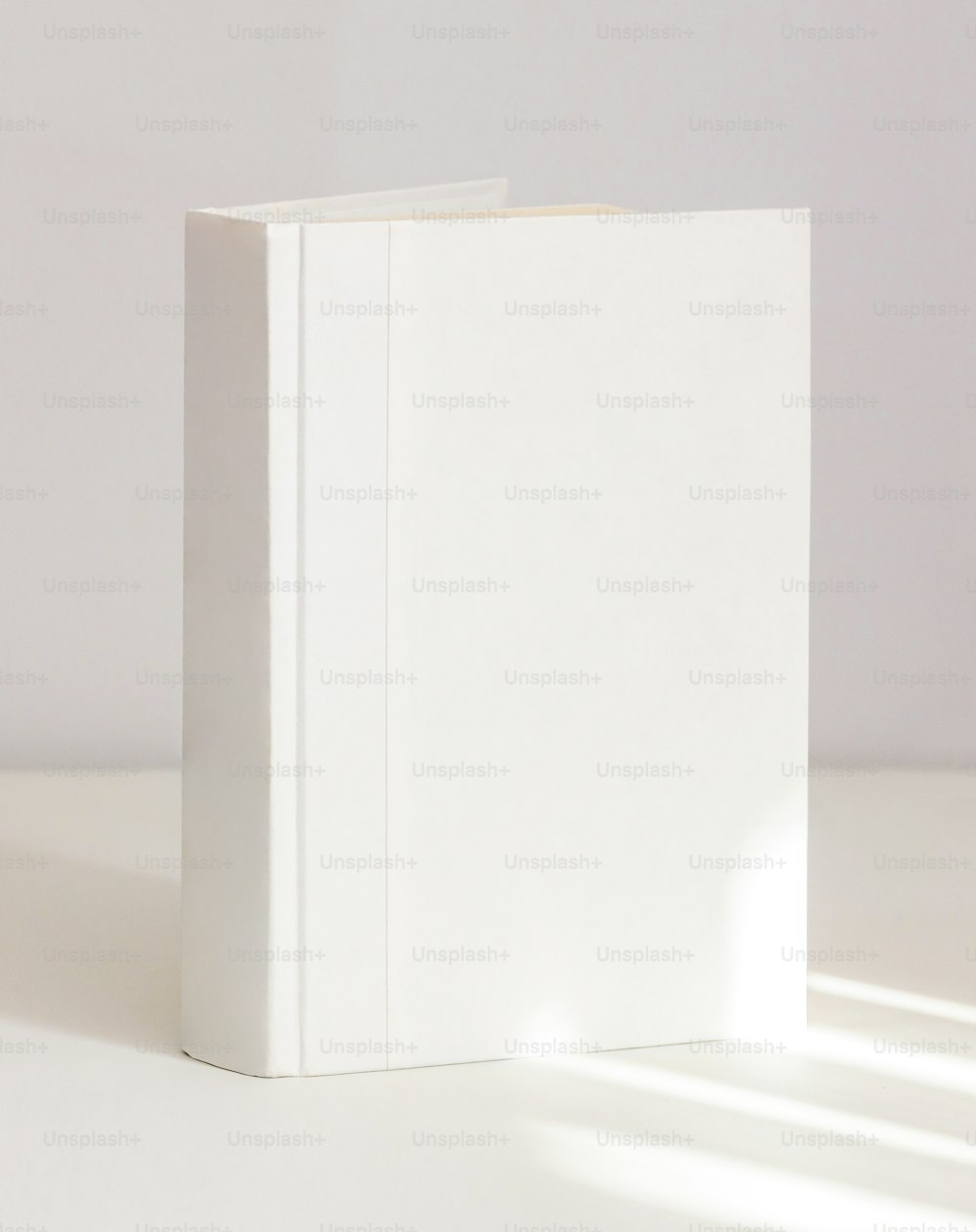 Ein weißes Buch auf einem weißen Tisch