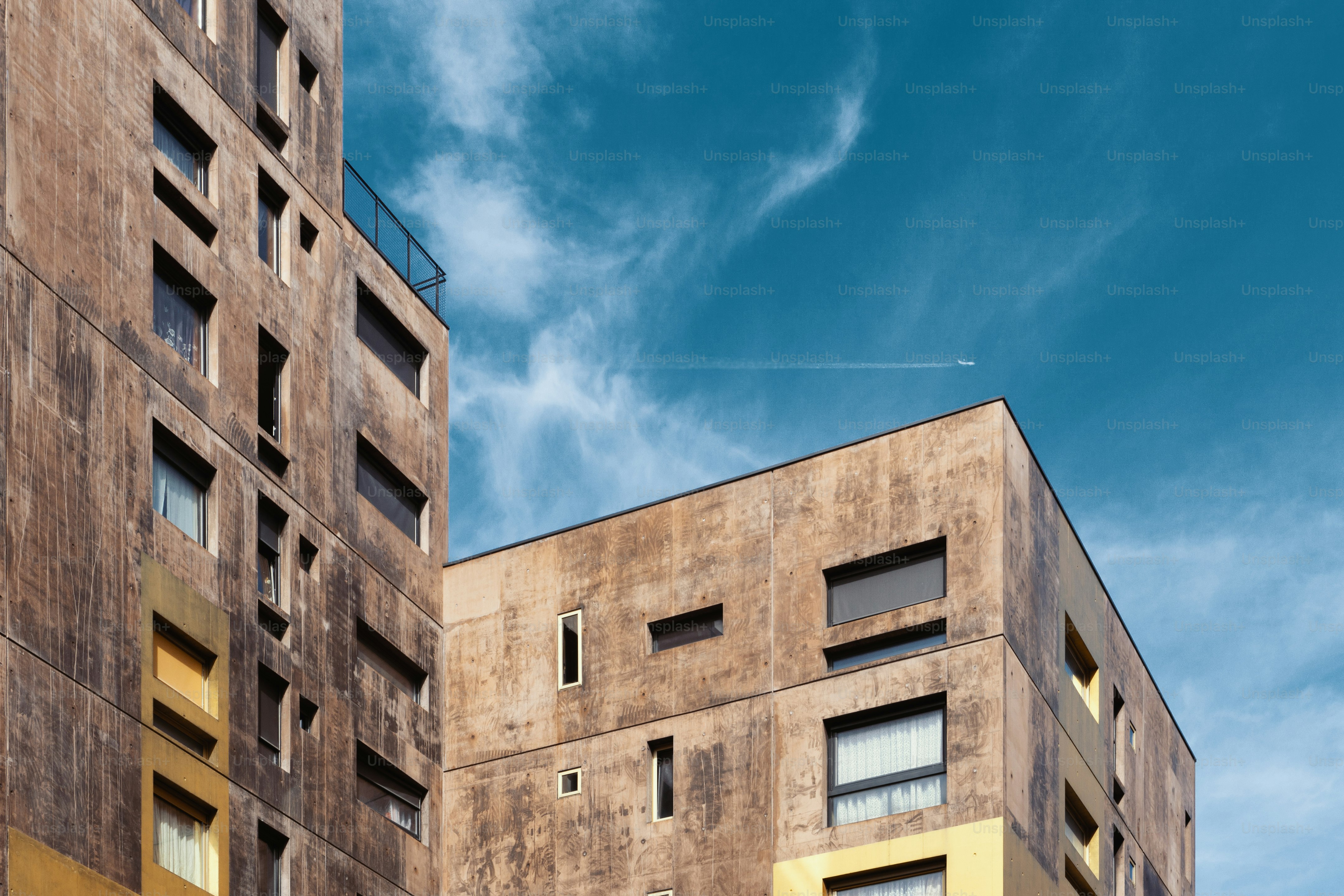 um edifício muito alto com um avião voando no céu