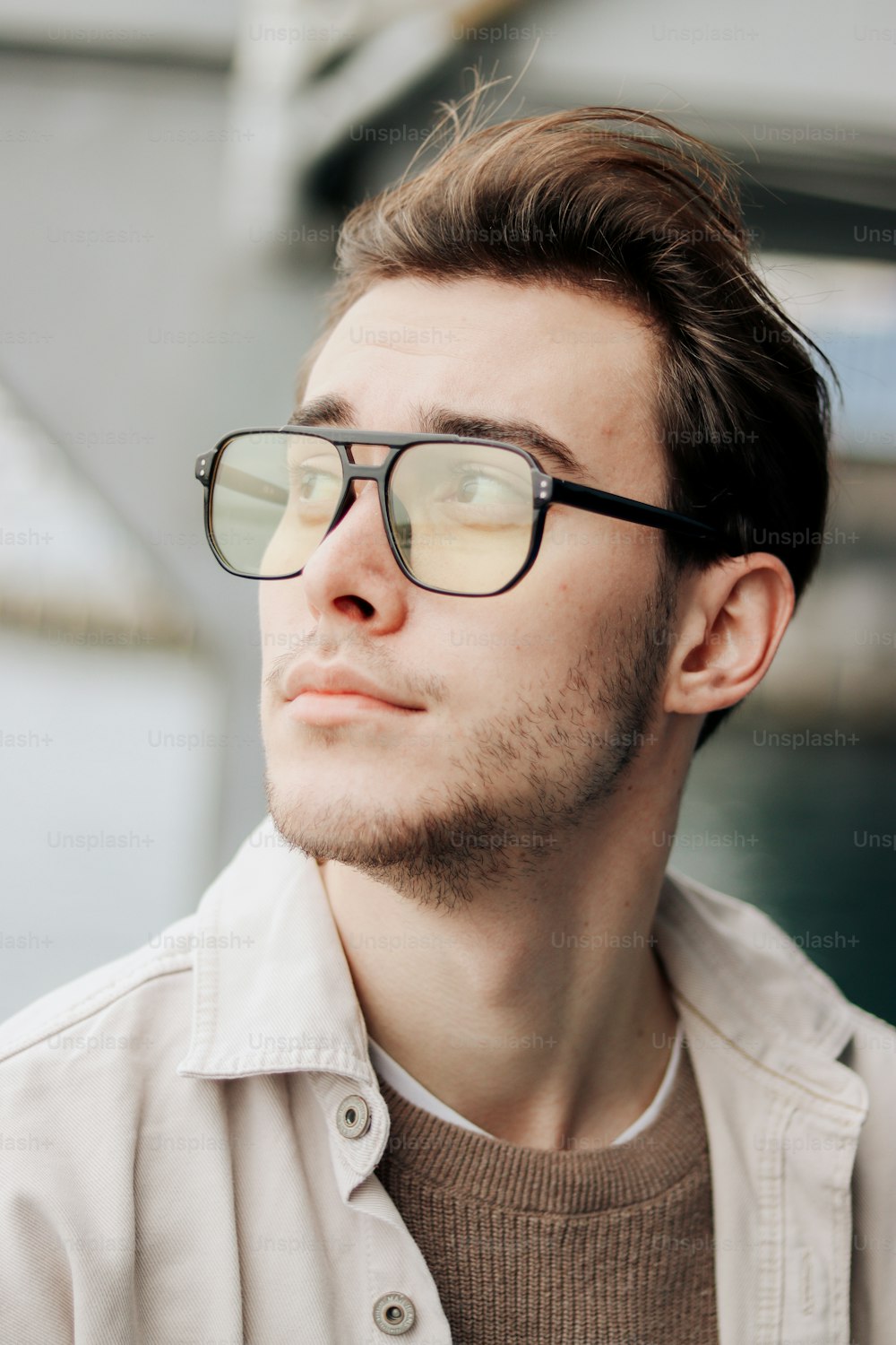 a man wearing glasses looking off into the distance