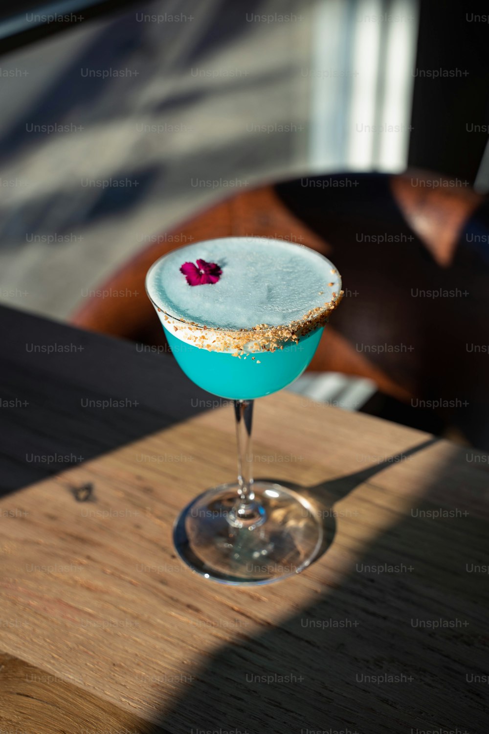 Ein blauer Cocktail auf einem Holztisch