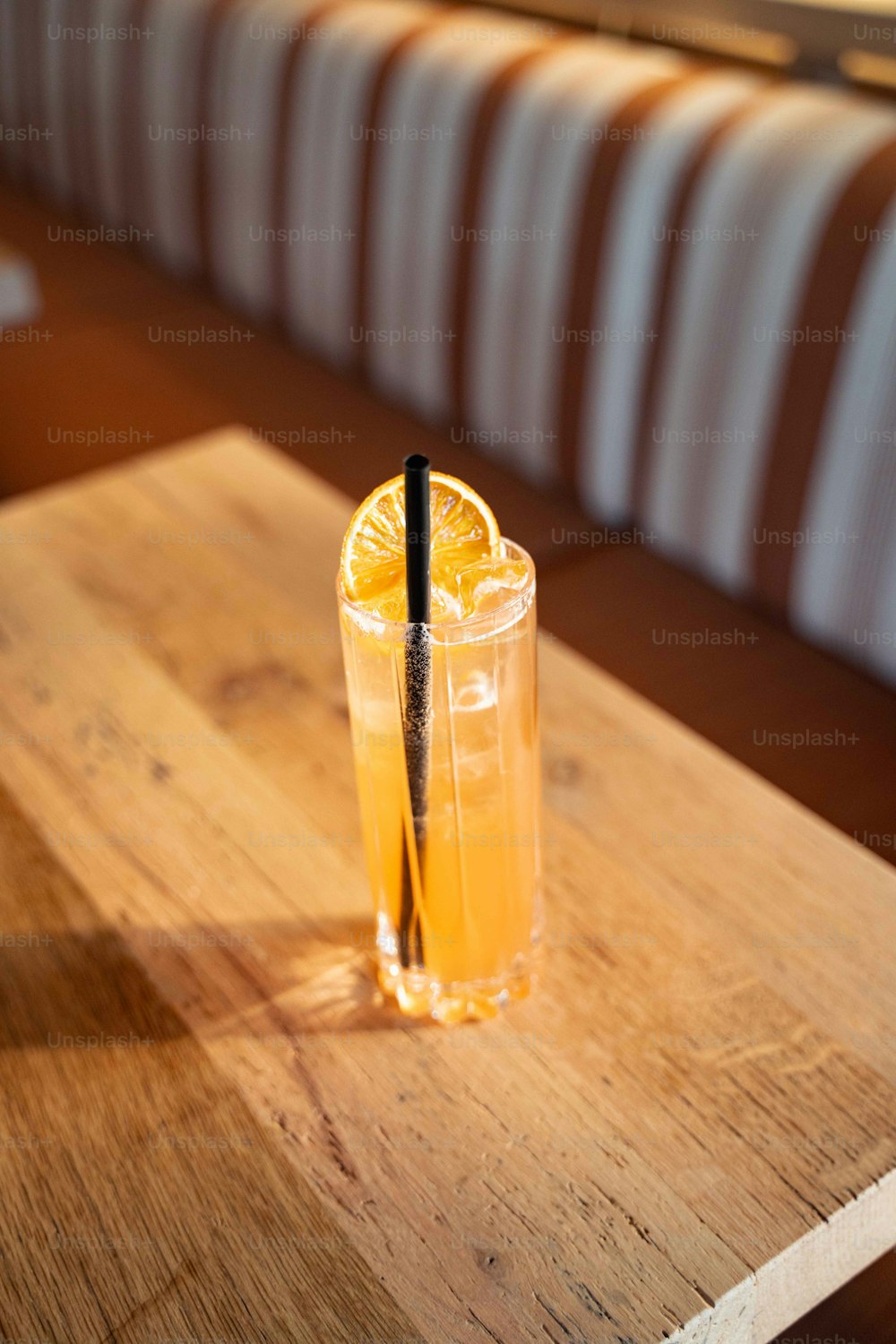 a glass of orange juice on a wooden table