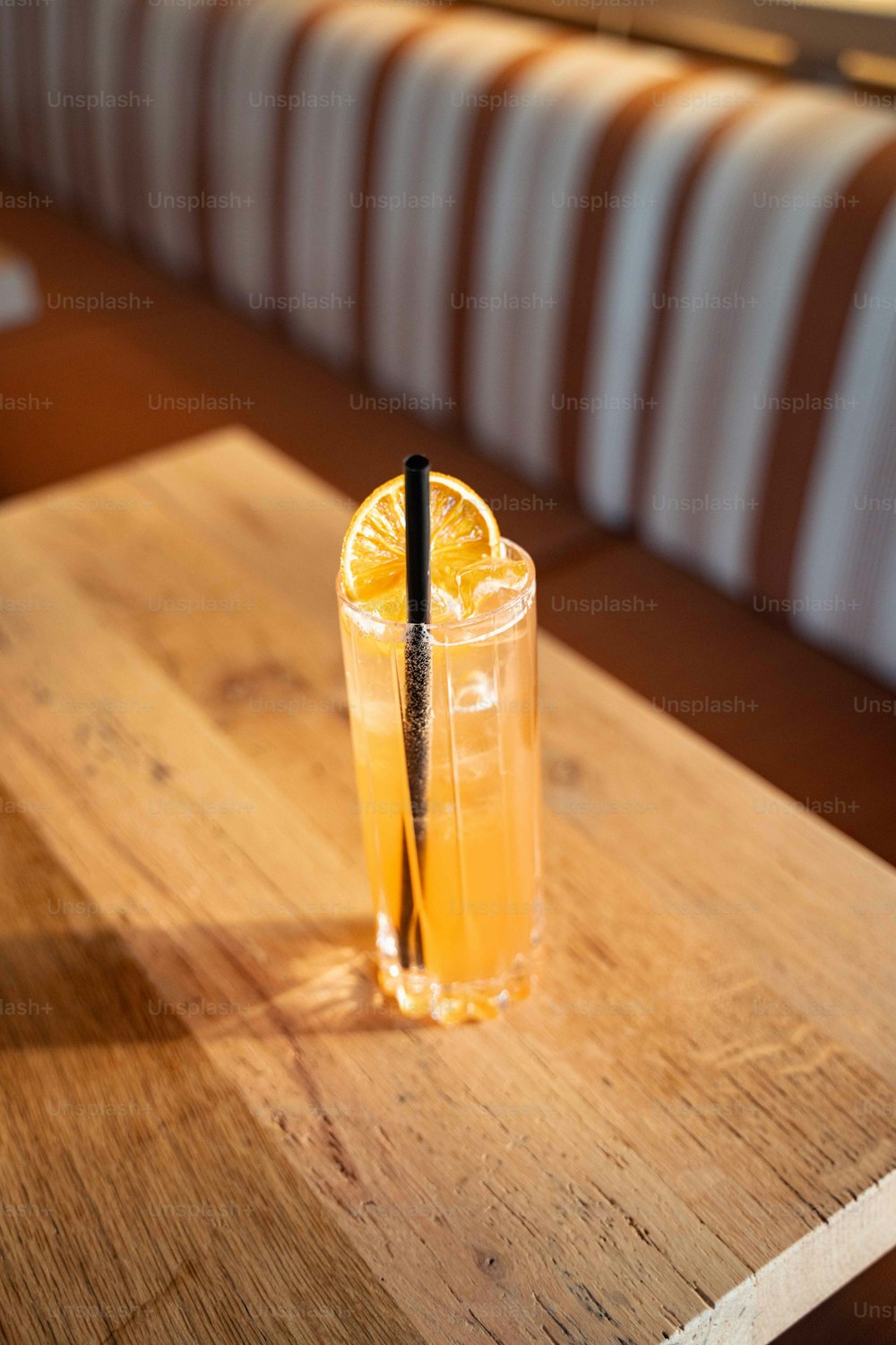 um copo de suco de laranja em uma mesa de madeira