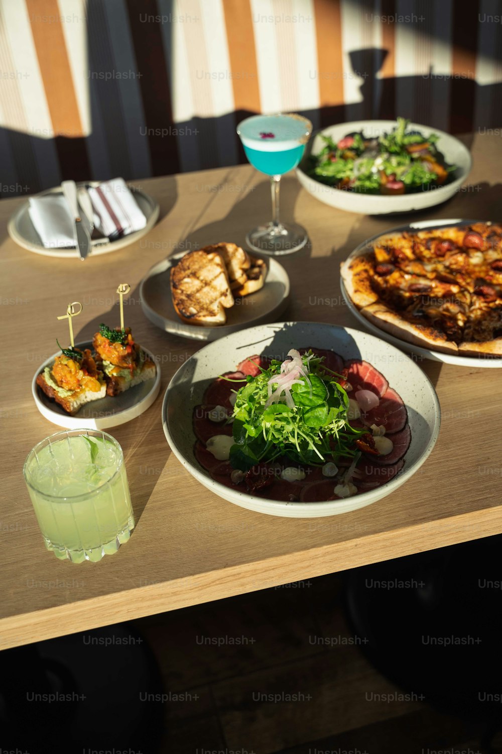 a wooden table topped with plates of food