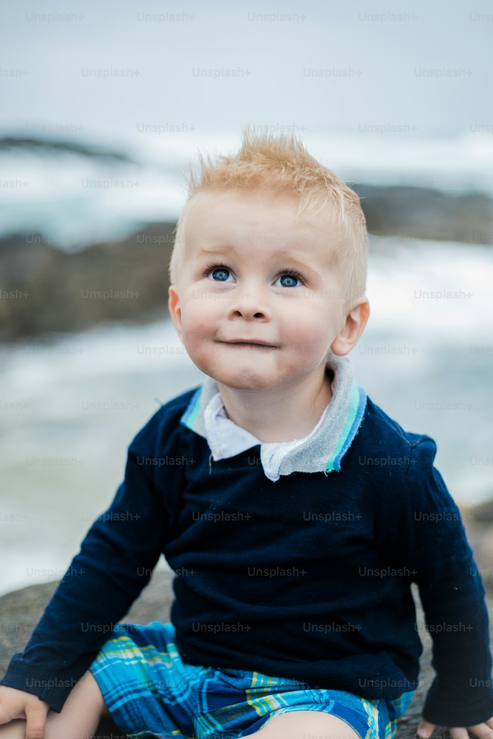 a little boy that is sitting on a rock