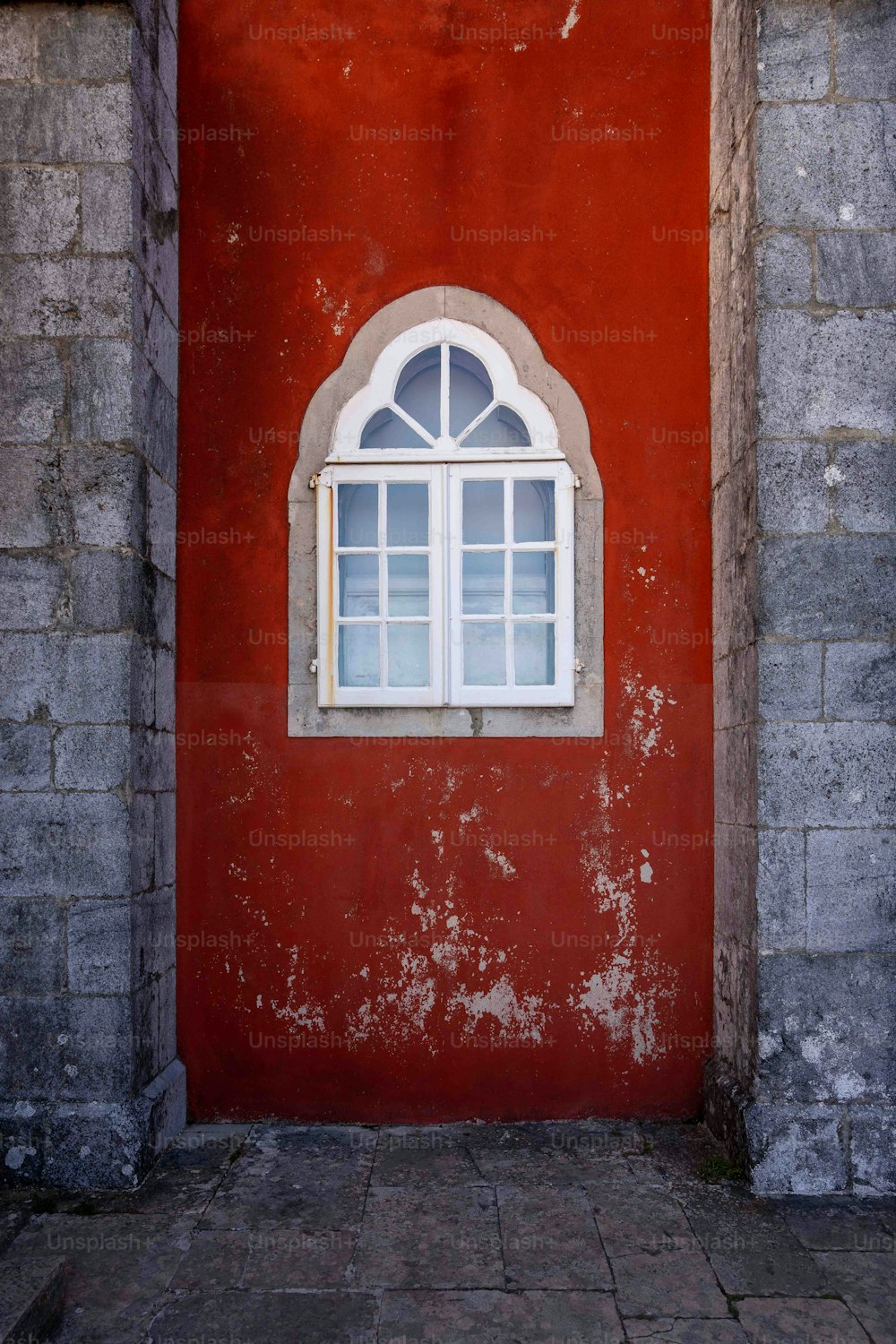 a red wall with a white window on it