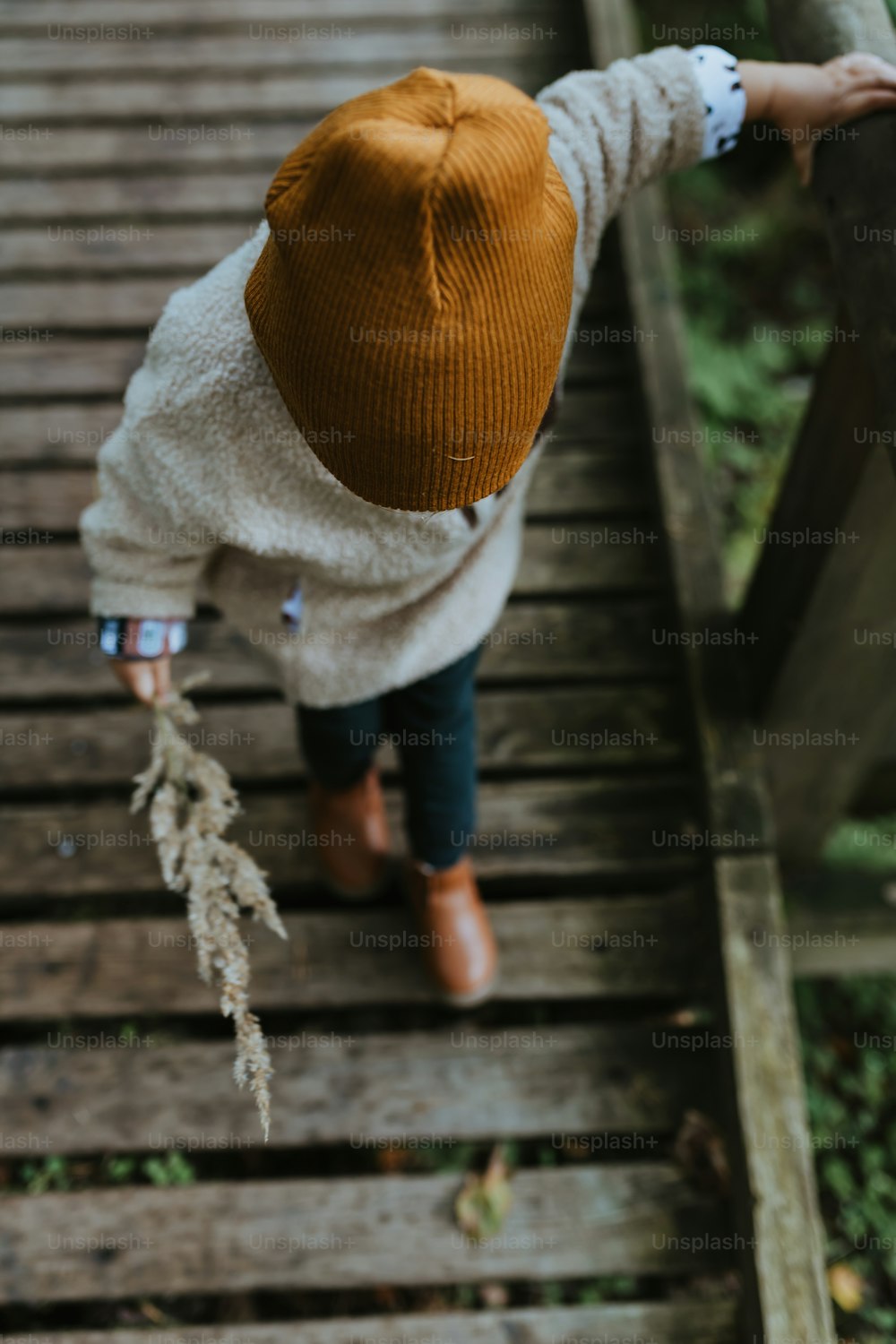 a small child walking up a wooden walkway
