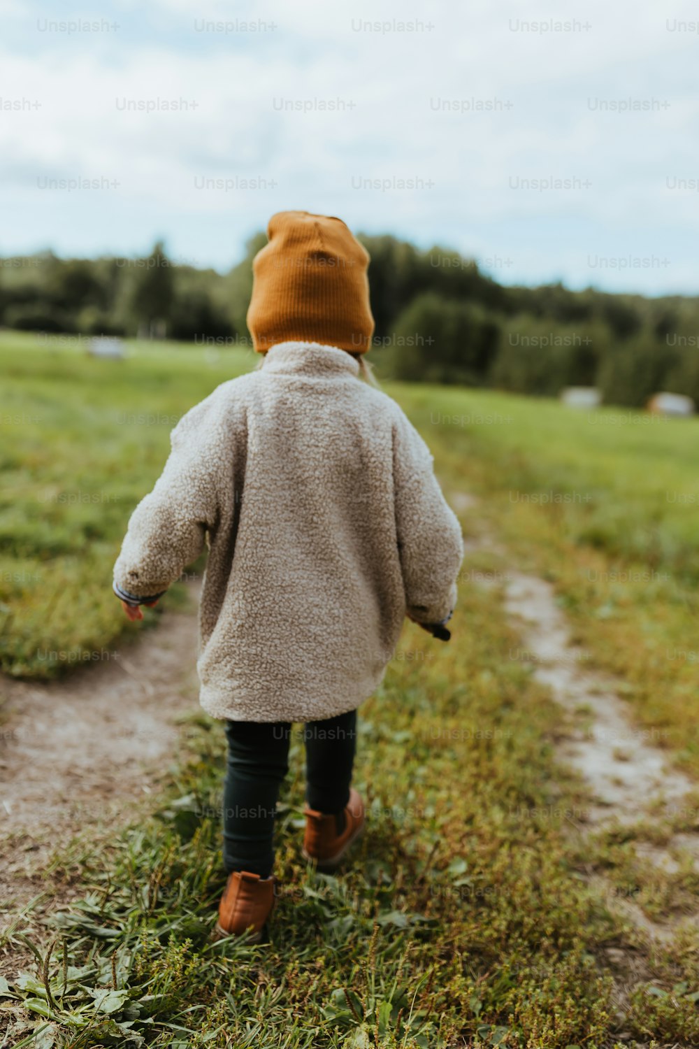 a little boy walking down a dirt road