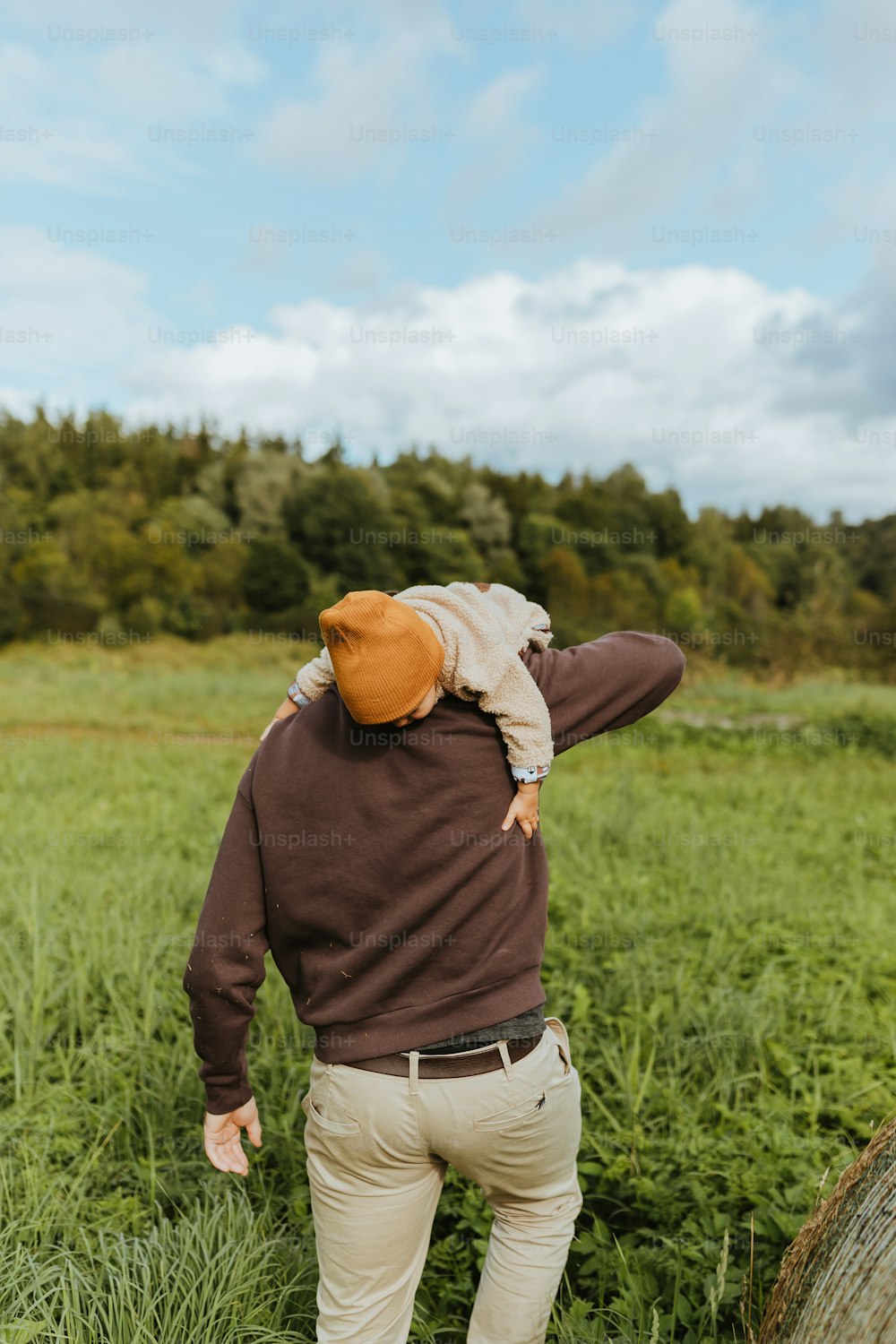 a man standing in a field with his back to the camera