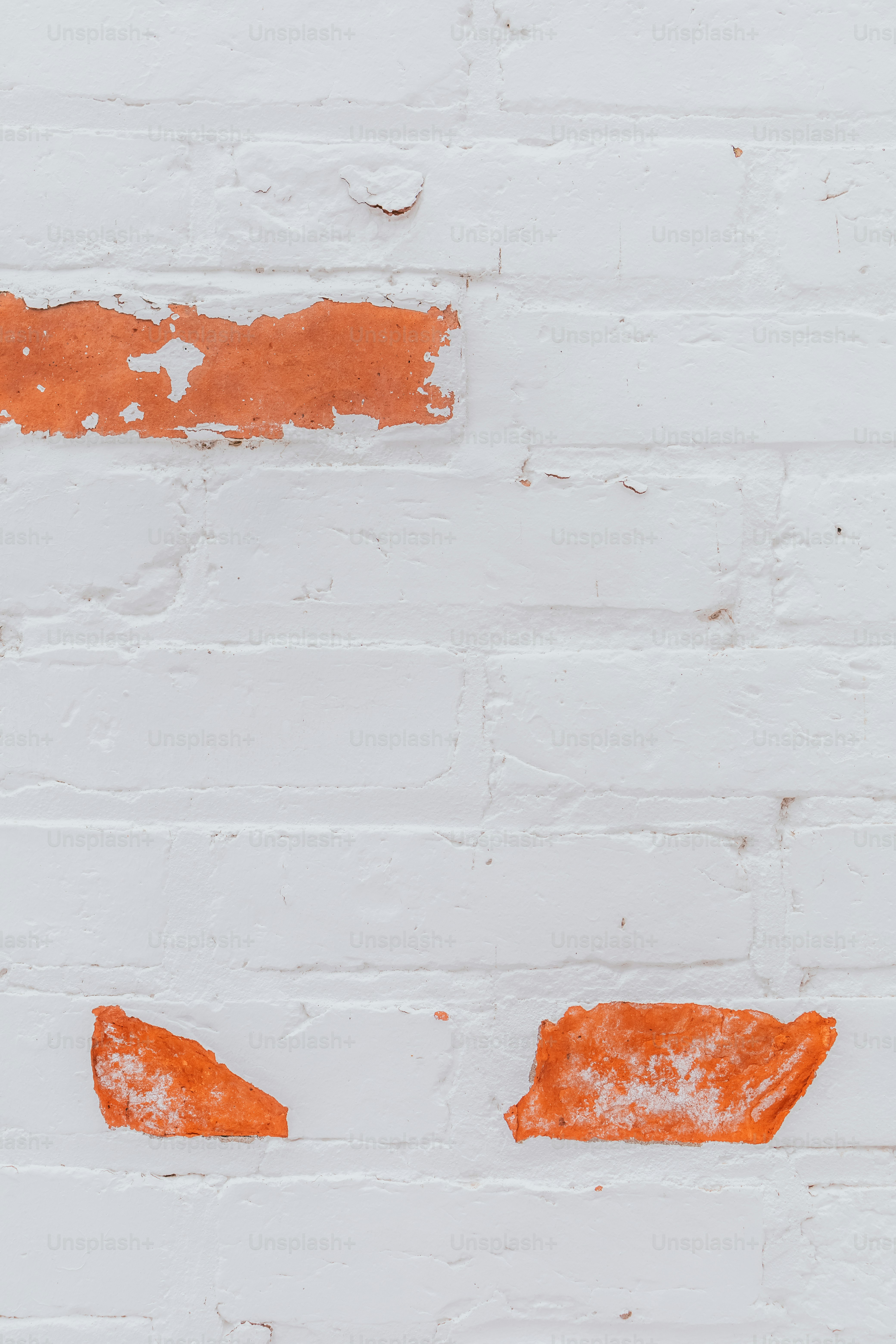a white brick wall with orange paint on it