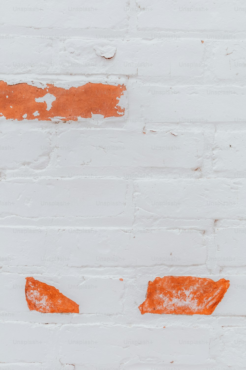 a white brick wall with orange paint on it