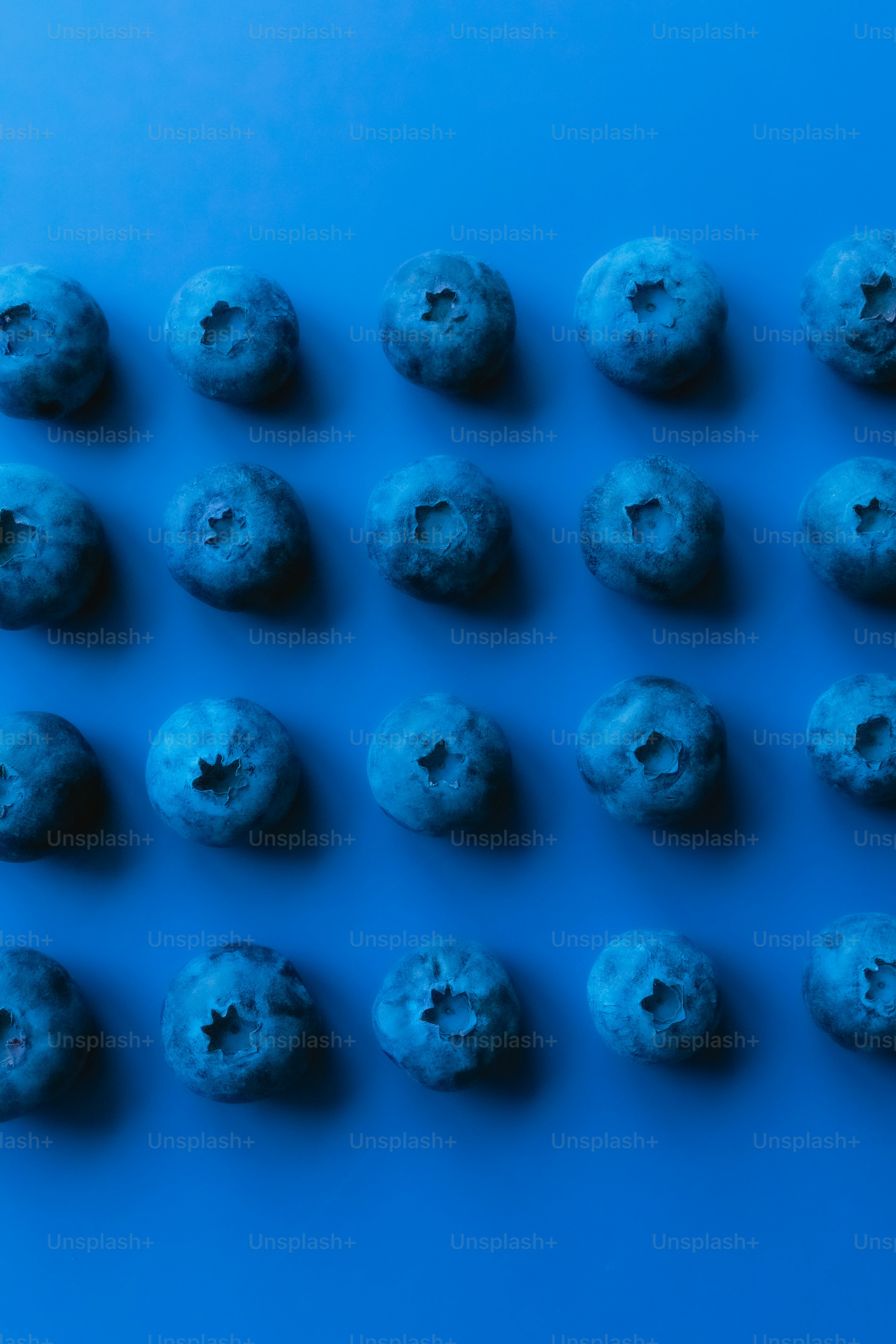 a group of blue doughnuts sitting on top of a blue table