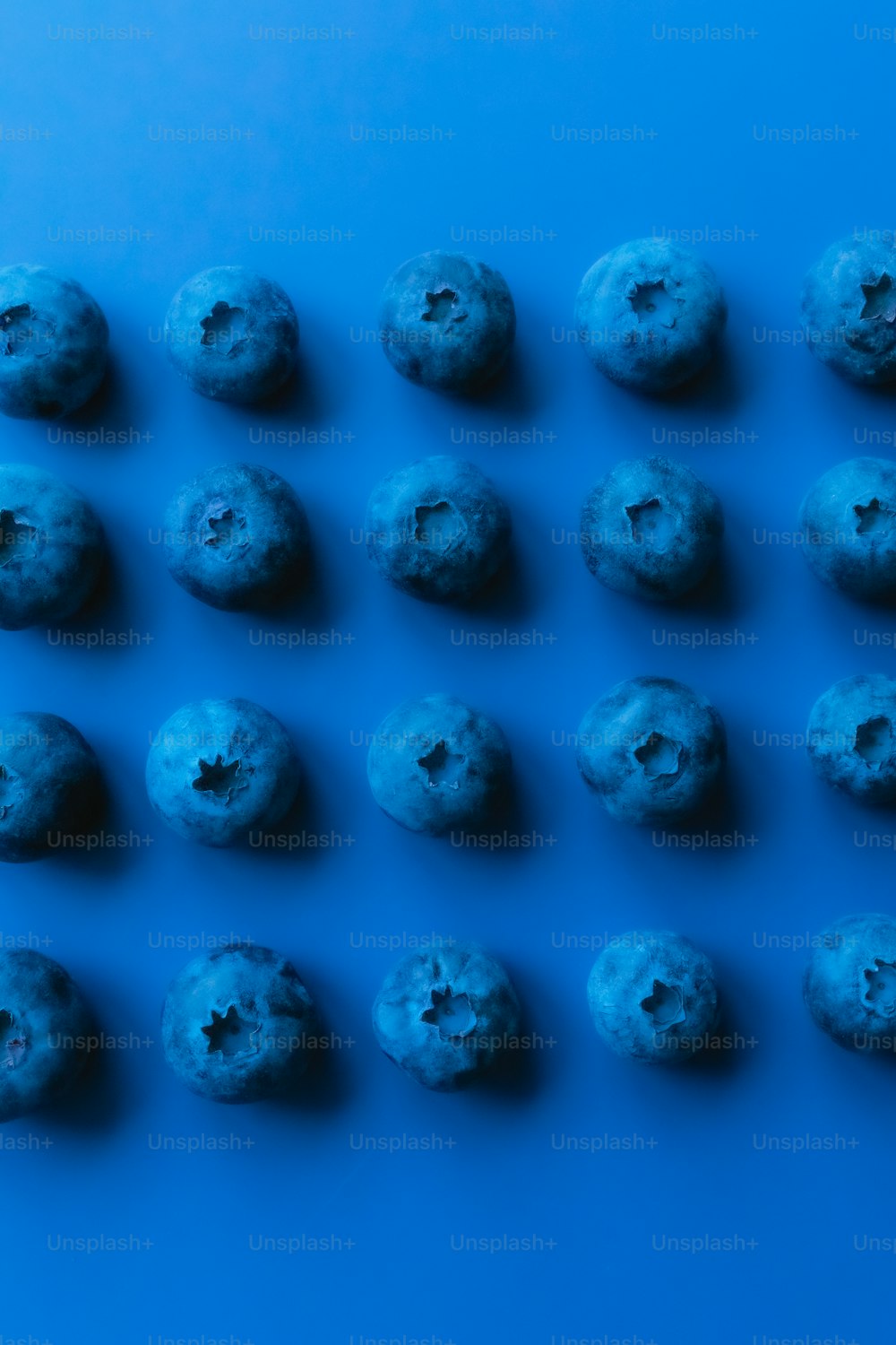 Un grupo de donuts azules sentados encima de una mesa azul
