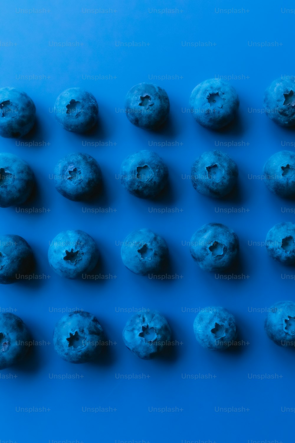 Un gruppo di ciambelle blu sedute in cima a un tavolo blu
