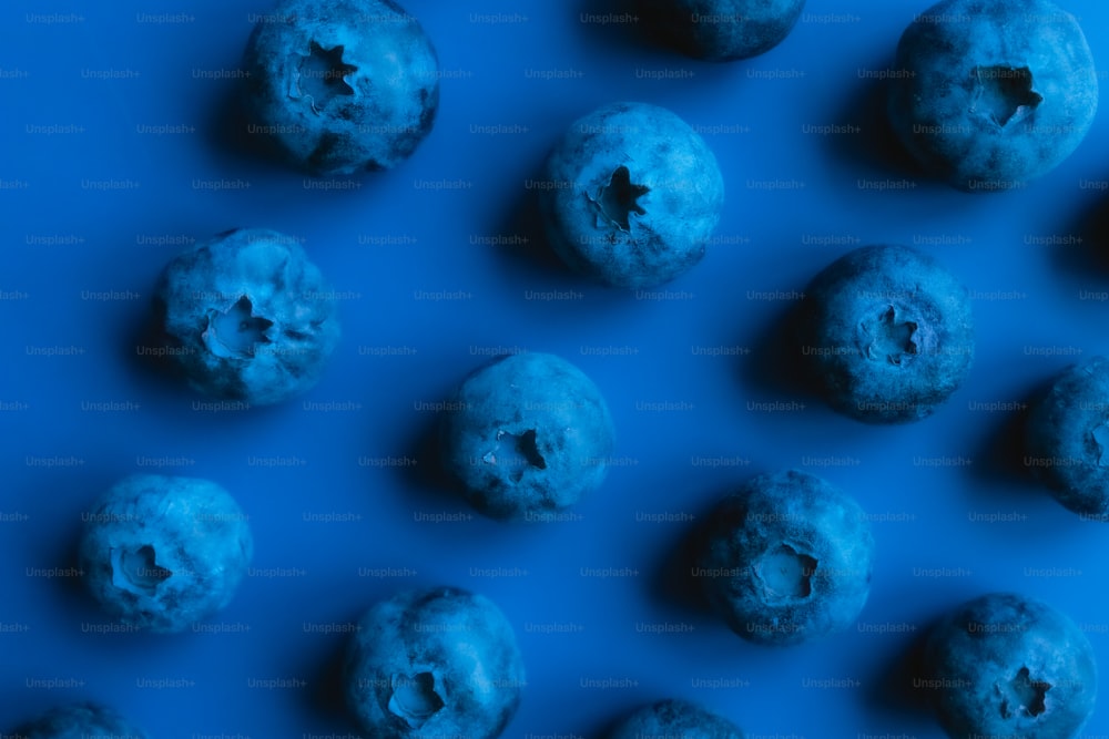 a group of blue doughnuts sitting on top of a blue surface