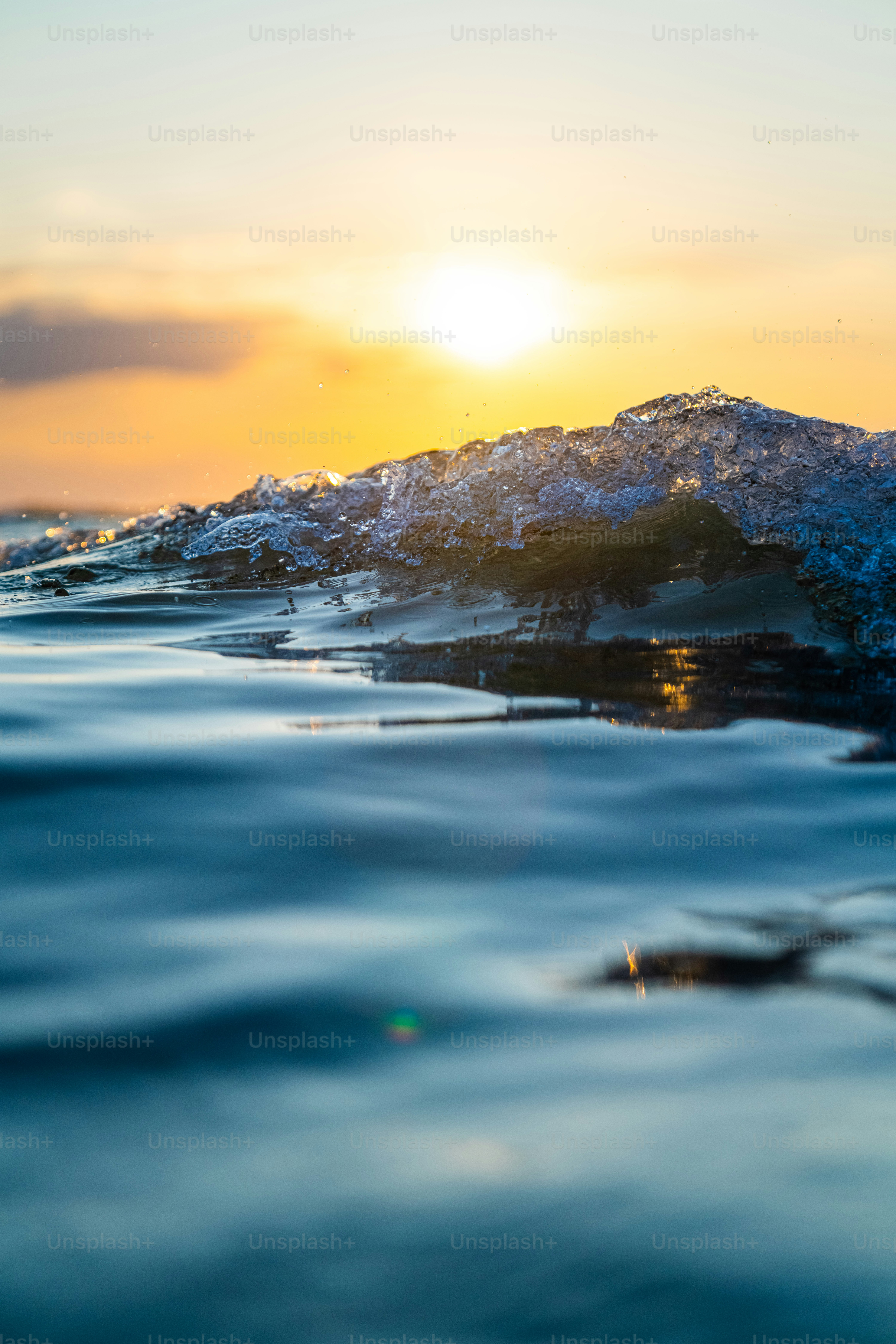 the sun is setting over the ocean waves