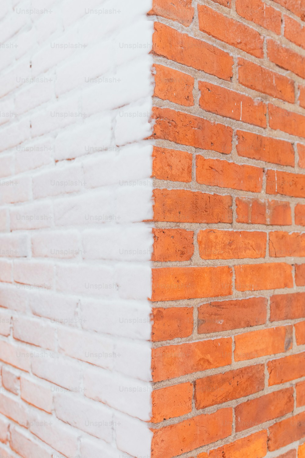a red brick wall with a white painted corner