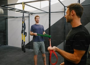 a man holding a pair of scissors in a gym