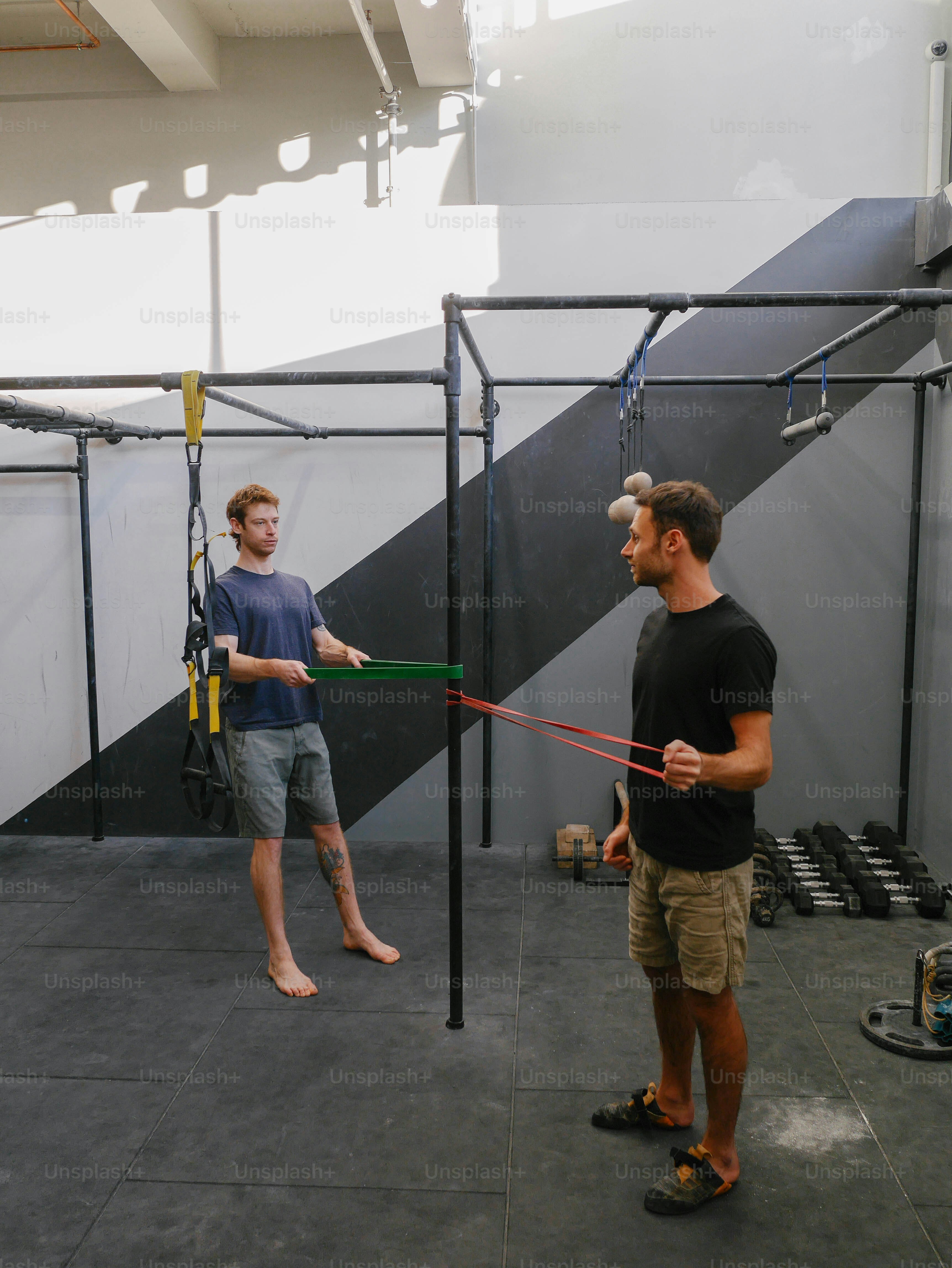 a man holding a baseball bat while standing next to another man