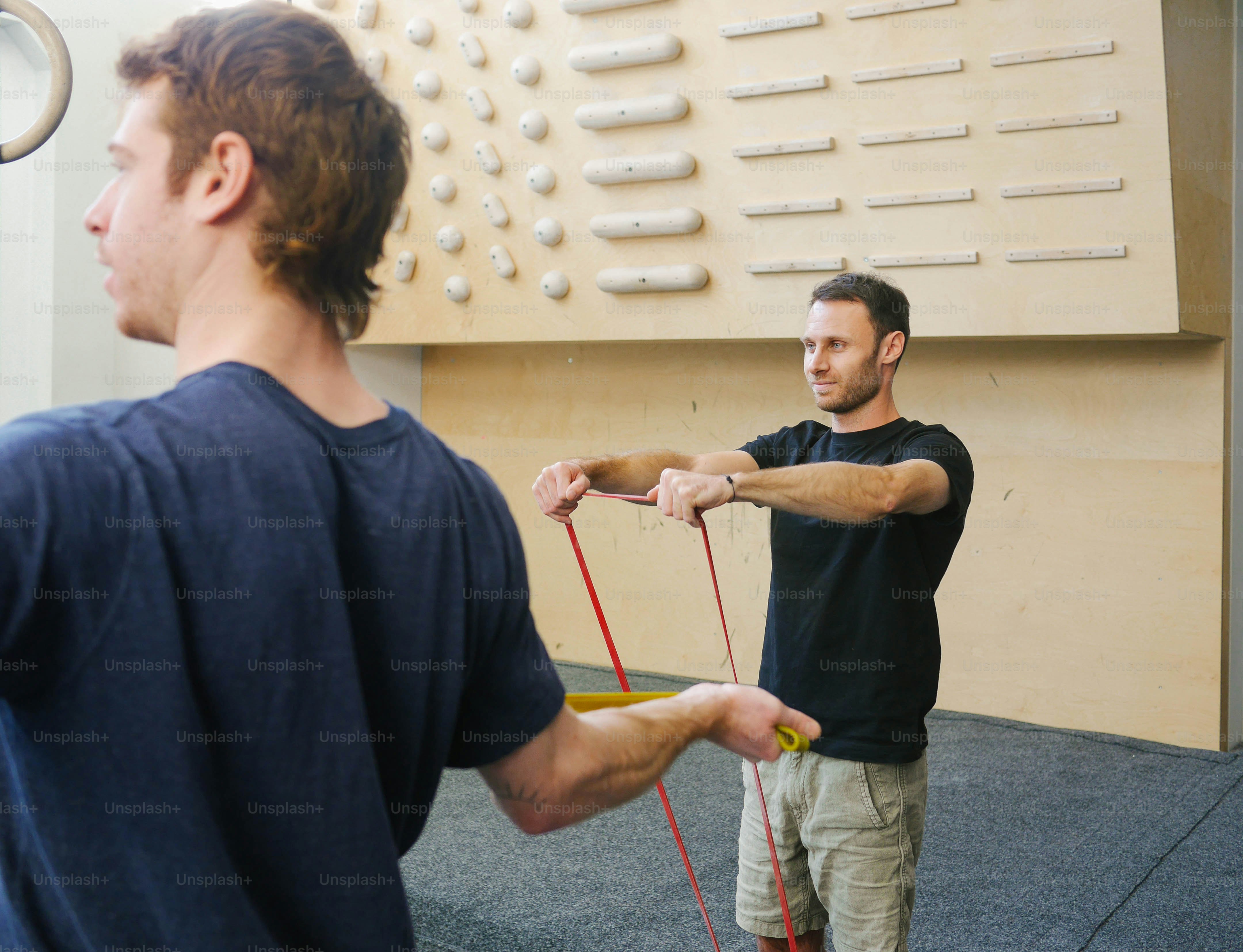 a man holding a rope while standing next to another man