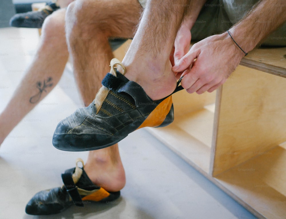 a man sitting on a bench tying his shoes