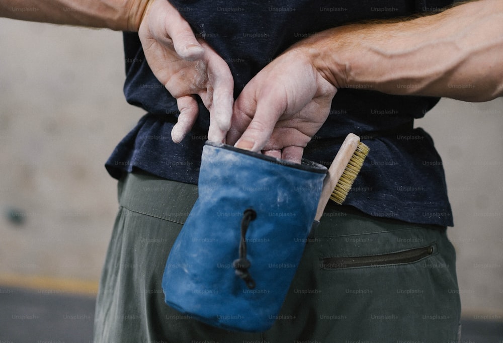 a man holding a blue pouch with a brush in it