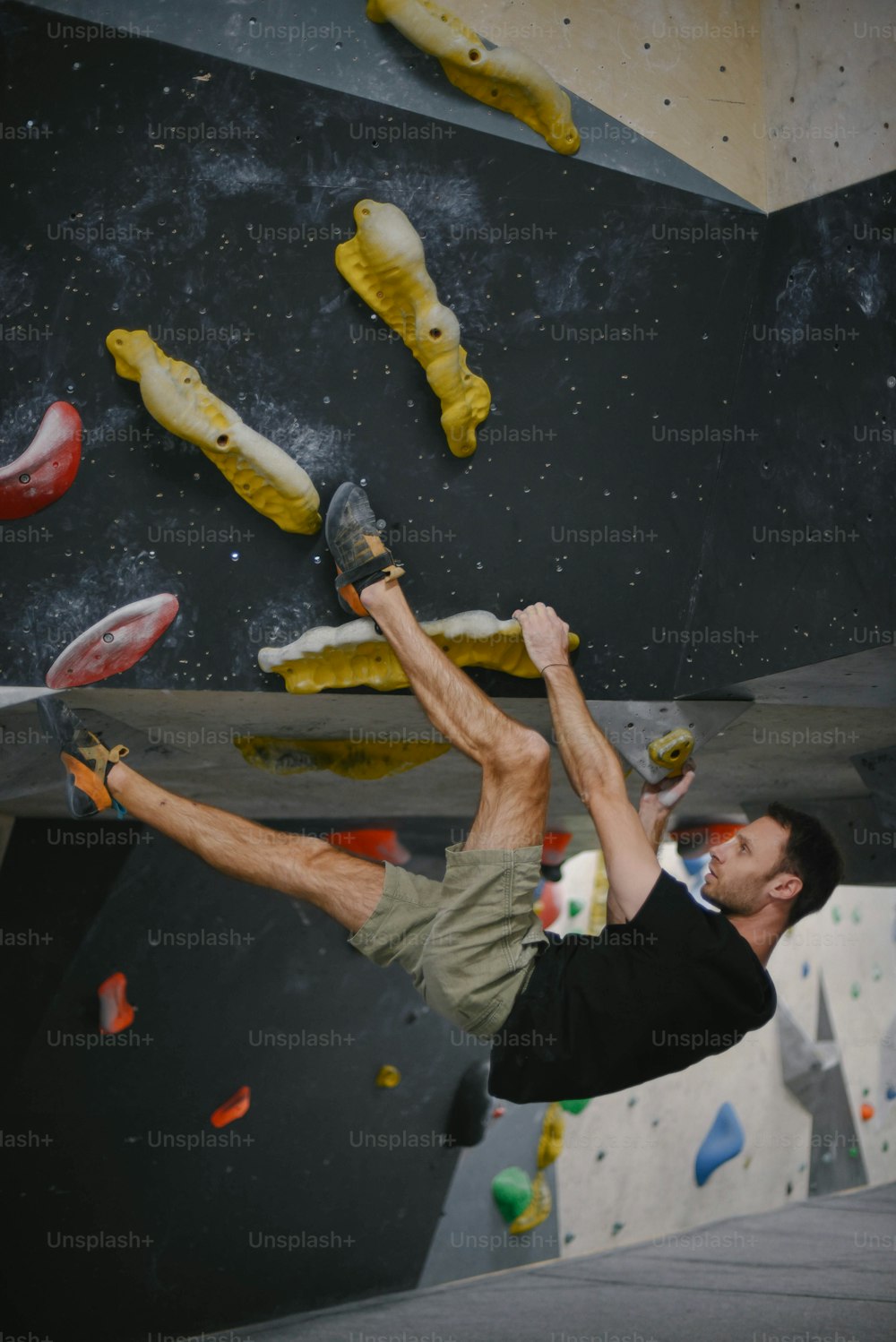 Un hombre en un muro de escalada haciendo un truco