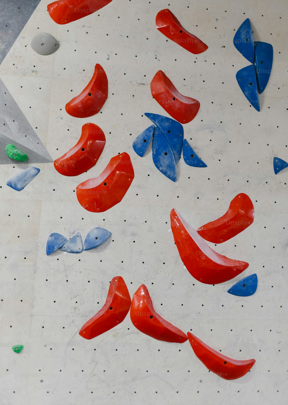 a climbing wall with red, blue, and green climbing equipment