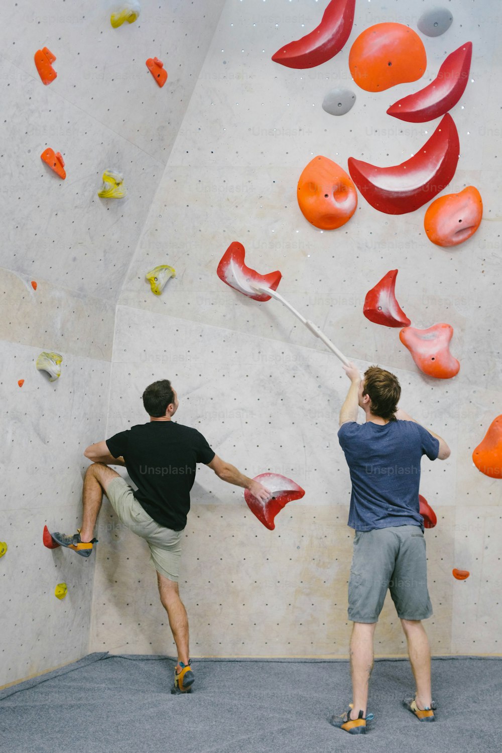 two men are climbing on a rock wall