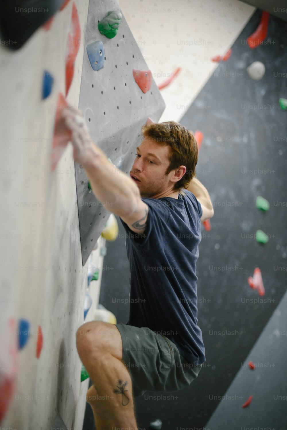 a man climbing up the side of a climbing wall