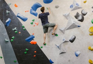 a man is climbing on a climbing wall