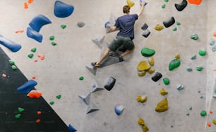 a man climbing up the side of a climbing wall