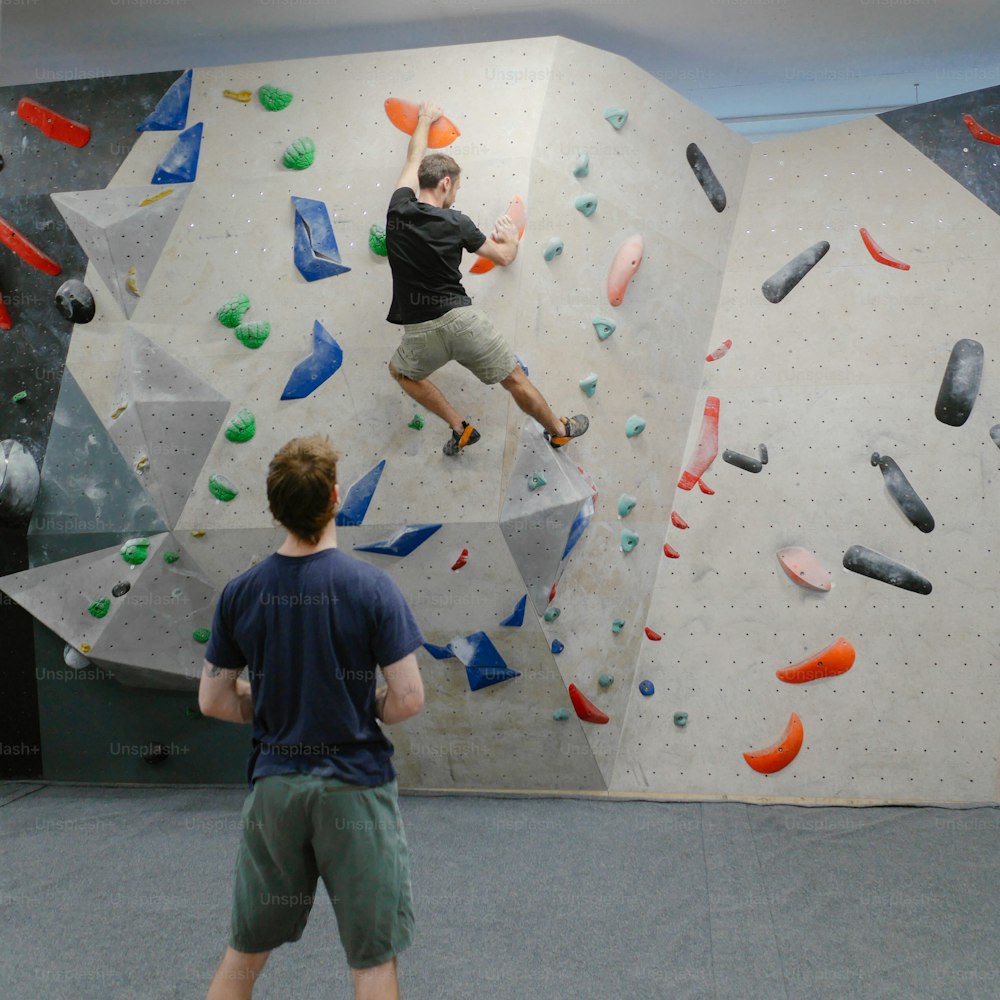 a man is climbing on a rock wall
