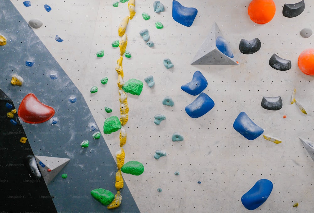 una parete da arrampicata con varie rocce colorate e attrezzature per arrampicarsi