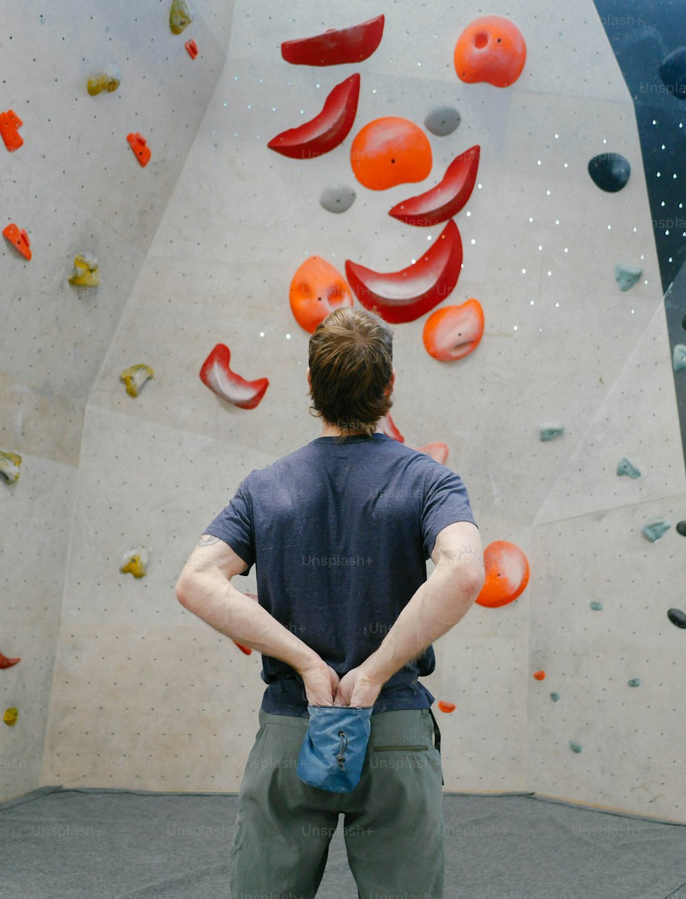 a man standing in front of a climbing wall
