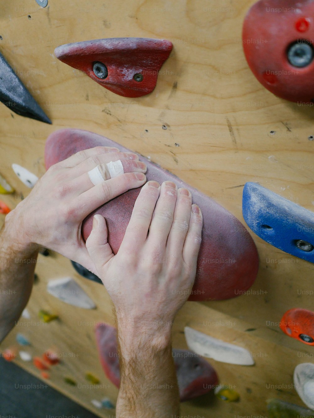a man holding his hand up to a climbing wall