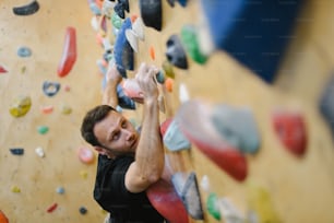 a man climbing up the side of a climbing wall
