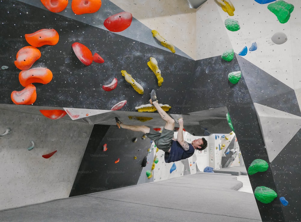 a man on a climbing wall with his hands in the air