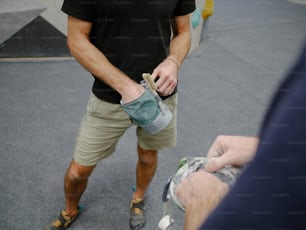 um homem segurando um par de sandálias em sua mão