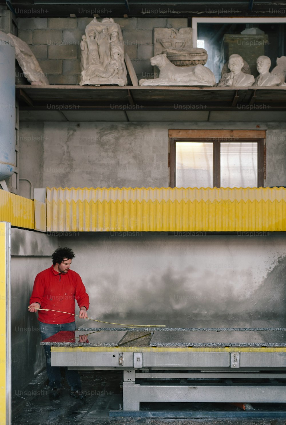 a man in a red jacket standing next to a table