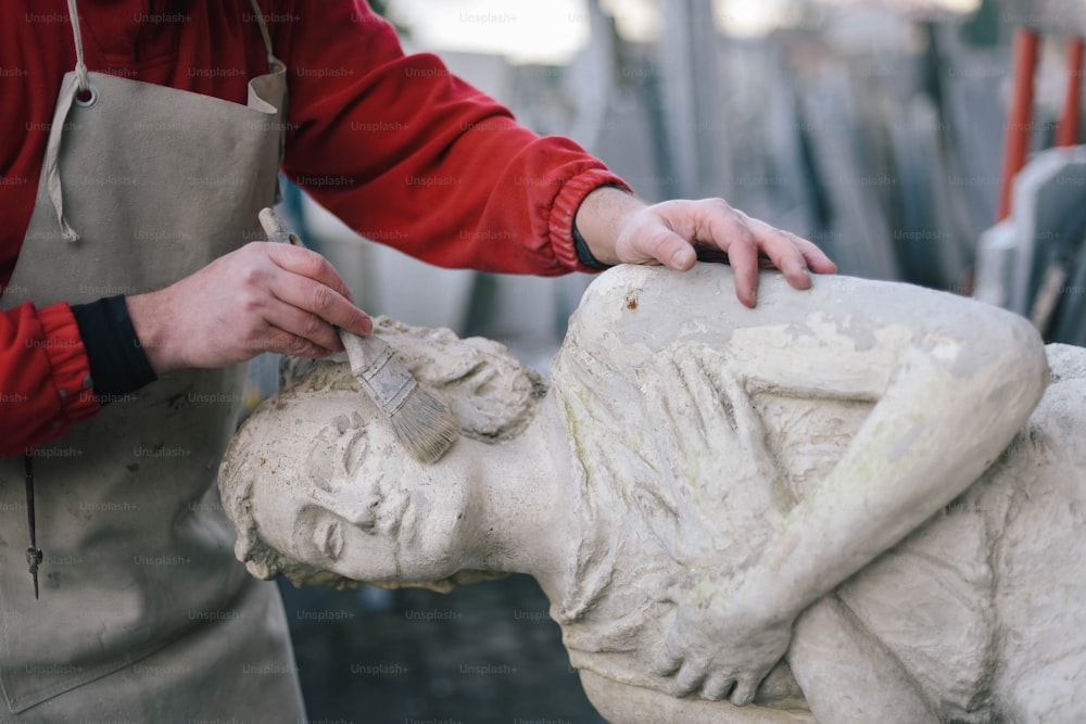 a man is working on a statue of a woman