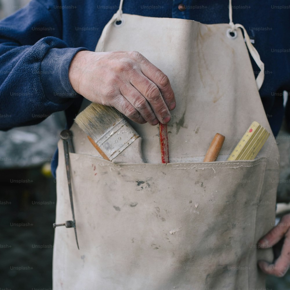 a person holding a paintbrush and a paint can