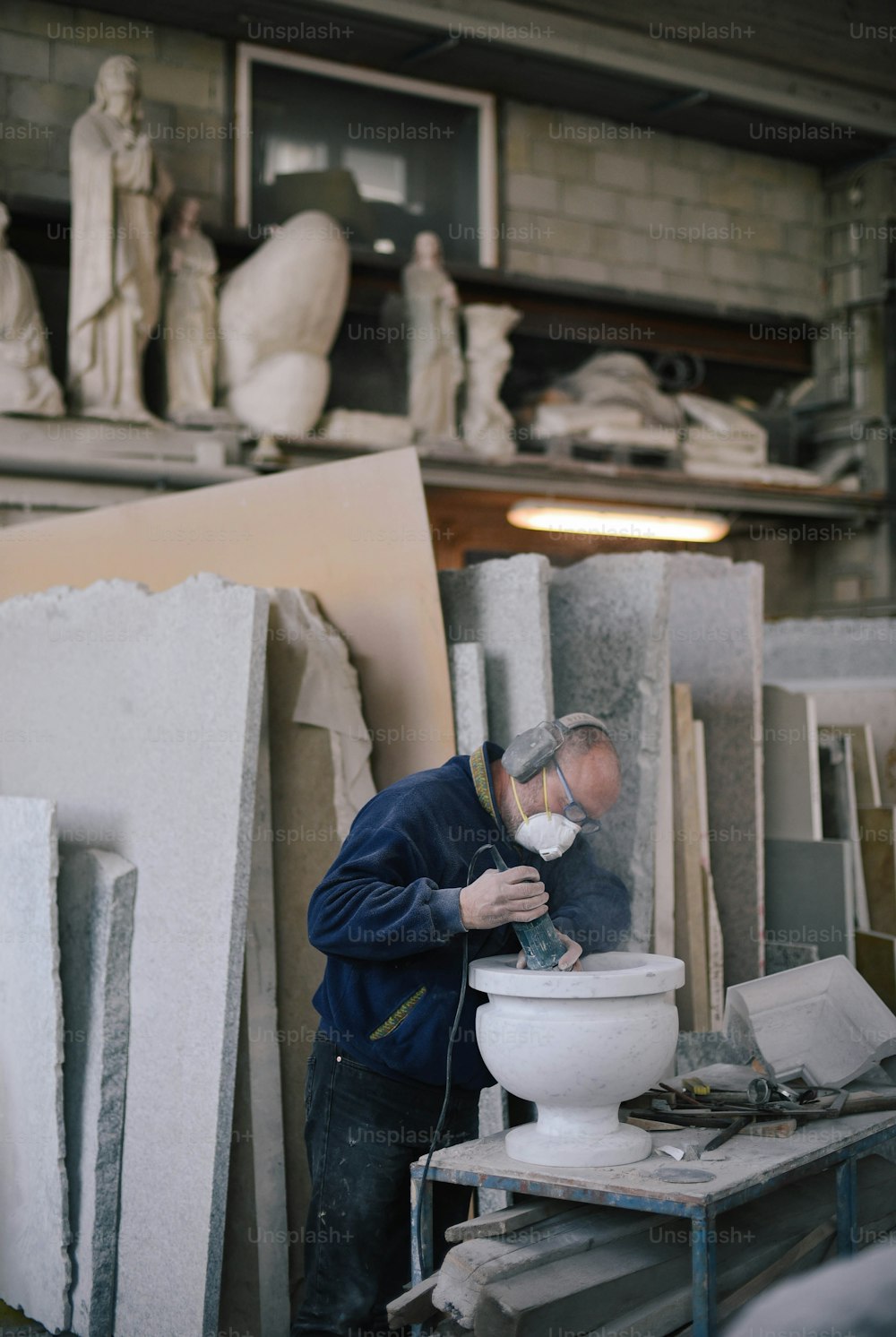 Ein Mann arbeitet in einem Atelier an einer Skulptur
