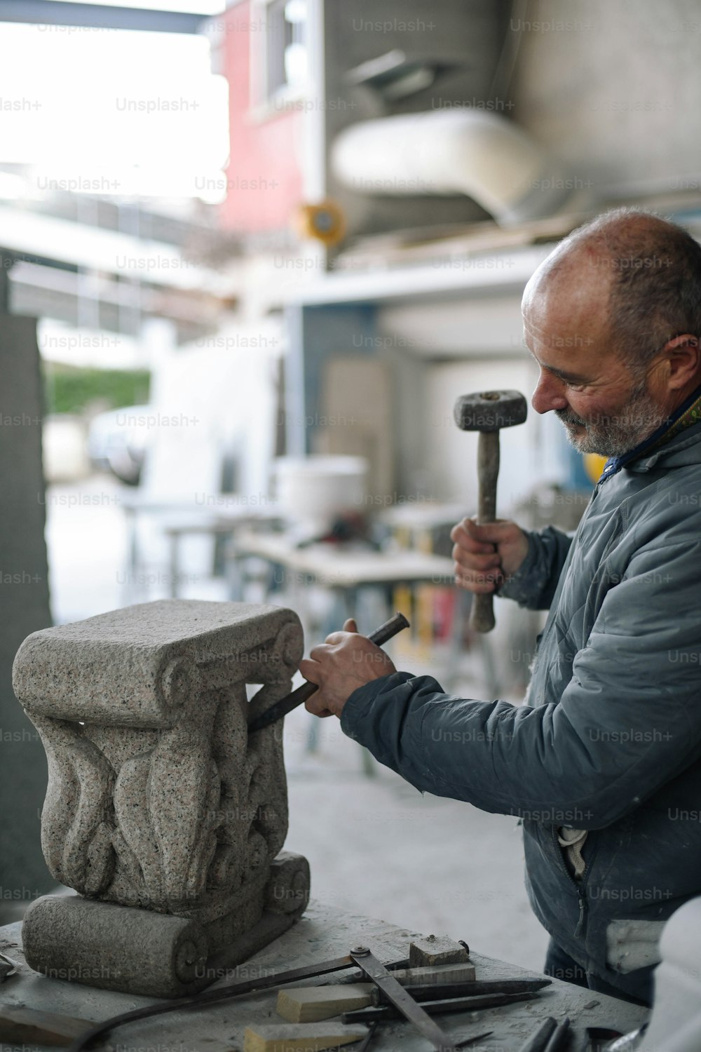 Un hombre está trabajando en una estatua con un martillo
