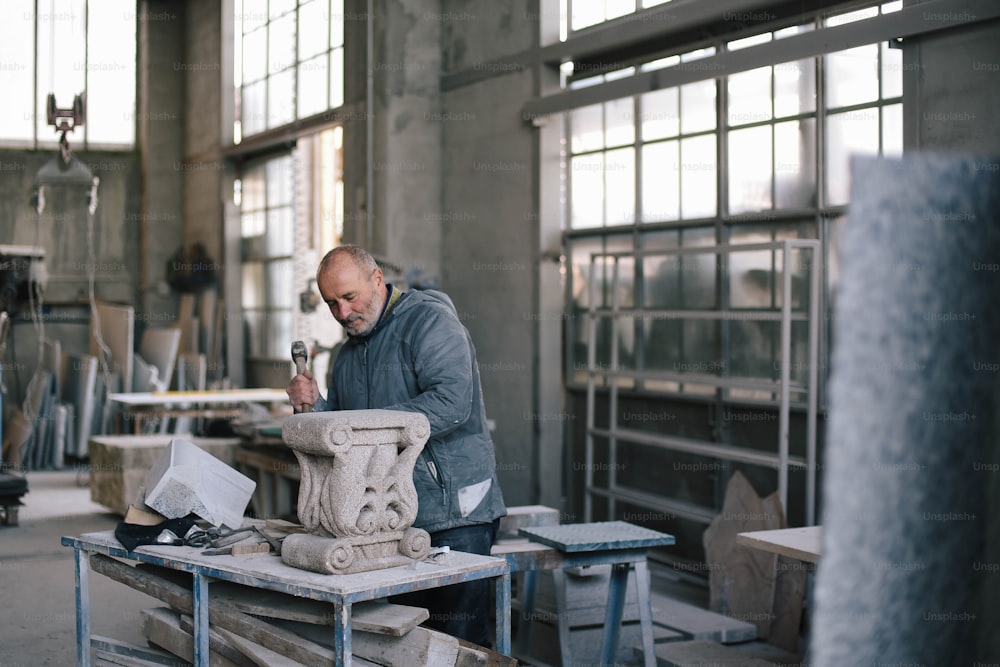 Un uomo che lavora su una scultura in una fabbrica