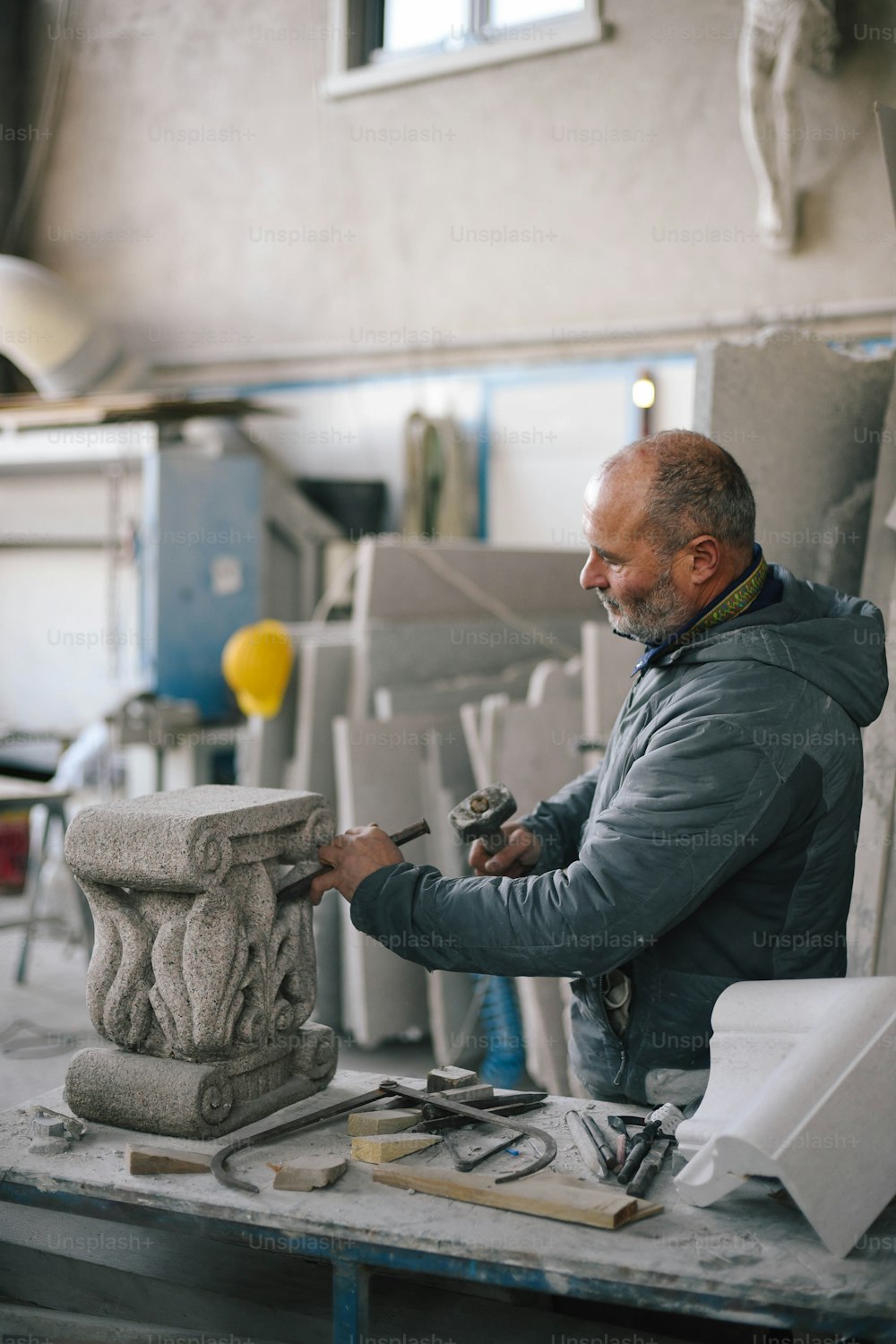 Ein Mann bei der Arbeit an einer Skulptur in einem Atelier