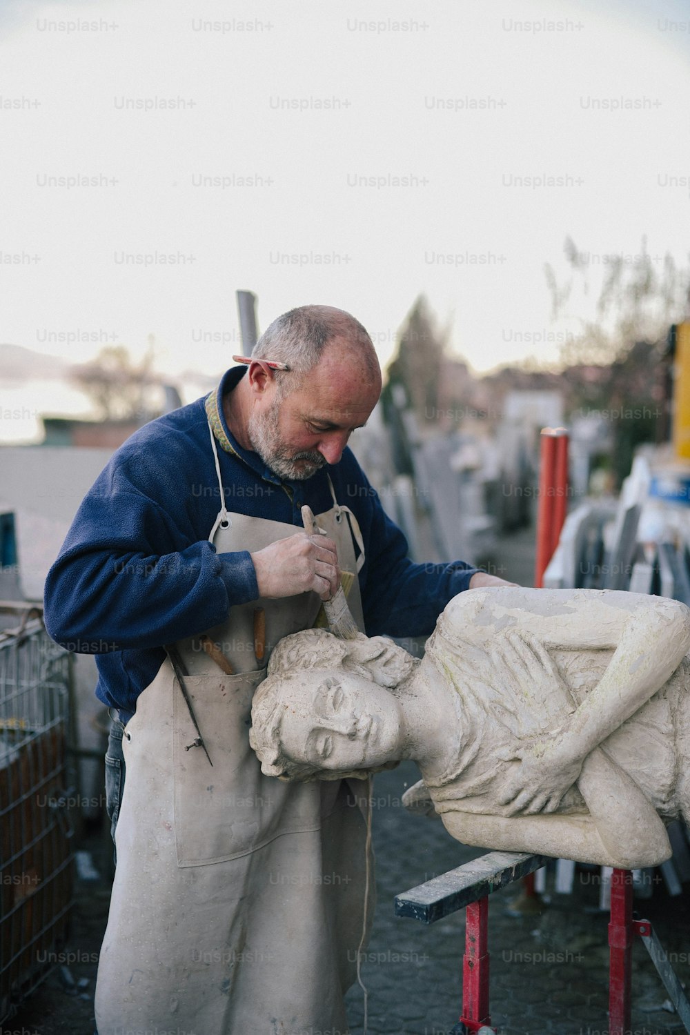 Un homme travaillant sur une statue dans un magasin