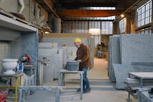 a man in a yellow hat is working in a factory