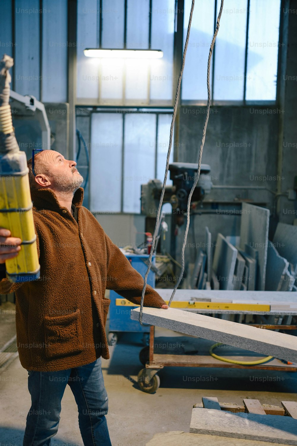 a man holding a yellow bottle in a factory