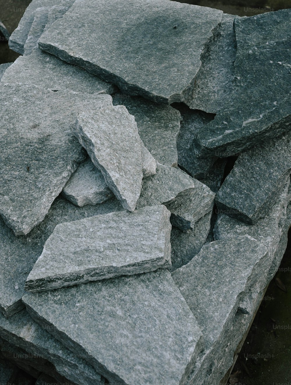 un mucchio di rocce grigie sedute in cima a un marciapiede
